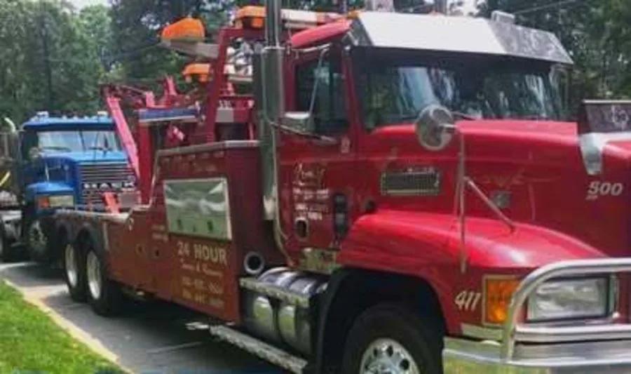 JMF red Mack wrecker with 24 hour service lettering on the door